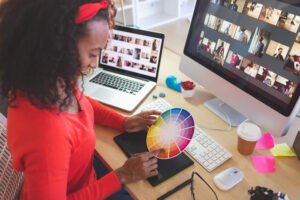 High angle view of young mixed-race female graphic designer using color swatch at desk in a modern office